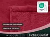 A close-up of a red blanket with text overlays and a certification logo. Produktbild-Vorschau