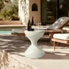 A stylish side table with wine bottles and glasses on a patio next to a pool and lounge chairs. Anteprima dell’immagine prodotto