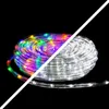 A coiled rope light with multicolor LEDs on one side and white LEDs on the other, set against a black background. Produktbild-Vorschau