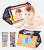 A baby playing with a sensory toy that includes a mirror and different textured surfaces. The collage also shows other views of the toy. Produktbild-Vorschau