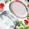 A close-up shot of a glass jar and its metal lid, surrounded by fresh ingredients like tomatoes, onions, and herbs. Voir les images du produit