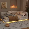 A bedroom scene featuring a white upholstered daybed with LED lighting underneath, decorated with pillows and blankets. A framed artwork hangs on the wall above. Náhľad obrázku produktu