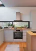 A modern kitchen with a built-in oven and a large window overlooking a natural landscape. Produktbild-Vorschau