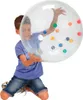 A young boy is holding a large, clear activity ball filled with colorful smaller balls. Produktbild-Vorschau