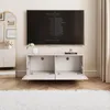 A modern living room with a TV mounted on the wall above a TV stand. The TV stand has its doors open, revealing storage compartments. A rug is in the foreground, and curtains are in the background. Voir les images du produit