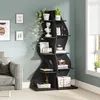 A black, modern, wavy bookshelf filled with books and decorative items, placed next to a grey sofa in a room with light blue walls. Podgląd zdjęcia produktu