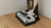 A close-up, cutaway view of a wet/dry vacuum cleaner's cleaning head and roller brush, showing the internal mechanism and how dirt and water are processed. Produktbild-Vorschau