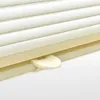 A close-up view of a cream-colored pleated blind mechanism with a beige lever. Produktbild-Vorschau
