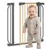 A baby stands in front of a baby gate. Náhled obrázku produktu