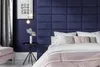 A bedroom scene with a bed and a padded headboard. Produktbild-Vorschau