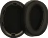 Two black ear pads for headphones are shown, one detached and one attached to a black plastic frame. Náhled obrázku produktu