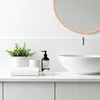 A clean and modern bathroom countertop with a sink, faucet, soap dispenser, plant, and folded towel. Produktbild-Vorschau