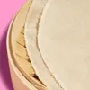 A close-up view of a bamboo steamer with fabric liners inside, set against a pink background. Produktbild-Vorschau