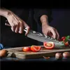 A person is cutting tomatoes on a wooden cutting board with a knife. Voir les images du produit