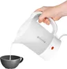 A hand is pouring water from a white electric kettle into a gray cup. Voir les images du produit