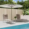 Two lounge chairs are set up by a pool, under a large umbrella, with plants in the background. Produktbild-Vorschau