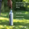 A hand holding a stainless steel water bottle with a blue loop, outdoors with a blurred green background. Produktbild-Vorschau