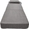 A folded-up grey mattress with a pillow on top, against a white background. Voir les images du produit