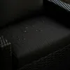 Close-up of a black cushion with water droplets on it, suggesting it is waterproof. Voir les images du produit