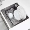 A dish rack with dishes and cutlery placed inside a sink. Produktbild-Vorschau