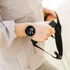 A person wearing a smartwatch and holding exercise equipment. Anteprima dell’immagine prodotto