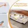 A white coffee table with LED lighting and drawers, shown in a living room setting with a rug and wooden floor. The image also includes close-ups of protective film being removed and the surface being cleaned. Produktbild-Vorschau