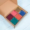 A cardboard box containing six colorful square magnetic tiles, arranged in two rows of three. Podgląd zdjęcia produktu