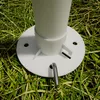 A close-up view of the base of a white pole, possibly part of a tent or canopy, resting on grass. Produktbild-Vorschau