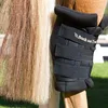 A close-up of a horse's leg with a black protective boot and its tail. Produktbild-Vorschau