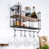 A wall-mounted kitchen shelf holding various jars and bottles, with mugs hanging below. Anteprima dell’immagine prodotto