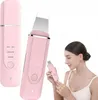 A woman is holding a pink facial cleansing device, with other images of the device in the background. Podgląd zdjęcia produktu