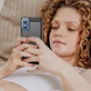 A woman is lying down and looking at her phone. Produktbild-Vorschau