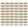 A grid of clear glass jars with gold lids. Voir les images du produit