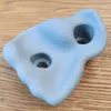 A single light blue climbing hold with two holes for mounting, placed on a wooden surface. Voir les images du produit