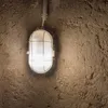 A close-up shot of a wall-mounted light fixture in a rough-textured environment. Produktbild-Vorschau