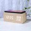 A digital alarm clock made of wood with a smartphone charging on top. Produktbild-Vorschau