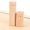 Two wooden blocks, one cylindrical and one rectangular, are placed on a wooden surface against a white background. Both blocks have two small dots representing eyes. Produktbild-Vorschau