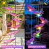 A split image showing a solar-powered wind chime with butterfly decorations. The left side shows the product in daylight, labeled 'Auto Charging in the sunshine'. The right side shows the product at night, illuminated and labeled 'Auto light up at night'. Produktbild-Vorschau