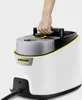 A hand is holding the handle of a white and gray Karcher steam cleaner. Voir les images du produit