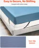 A mattress with a blue fitted sheet is shown on a bed frame, with straps underneath to secure it. A close-up of the bottom texture is also shown. Produktbild-Vorschau