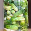 A close-up shot of a glass jar filled with pickles and dill. Podgląd zdjęcia produktu