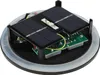 The internal components of a solar-powered LED light are shown, including solar panels, a circuit board, and a battery. Produktbild-Vorschau