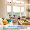 A living room with a sofa, chairs, and a large window overlooking a scenic landscape. A security camera is mounted near the window. Podgląd zdjęcia produktu