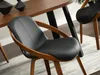 A close-up shot of a black leather dining chair with a wooden frame, placed next to a wooden dining table. Voir les images du produit