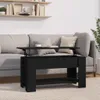 A black lift-top coffee table is shown in a living room setting, placed in front of a sofa. Voir les images du produit