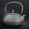 A dark, textured background highlights a metallic gray teapot. Podgląd zdjęcia produktu