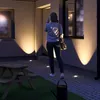 A woman stands on a paved patio at night, illuminated by ground lights, near a picnic table and a watering can. Produktbild-Vorschau
