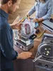 A man and a woman are preparing food using a sous vide cooker in a kitchen. Produktbild-Vorschau