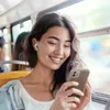 A young woman is riding on a bus and looking at her phone. Anteprima dell’immagine prodotto