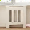 A white radiator cover with vertical slats is shown in a room. Anteprima dell’immagine prodotto